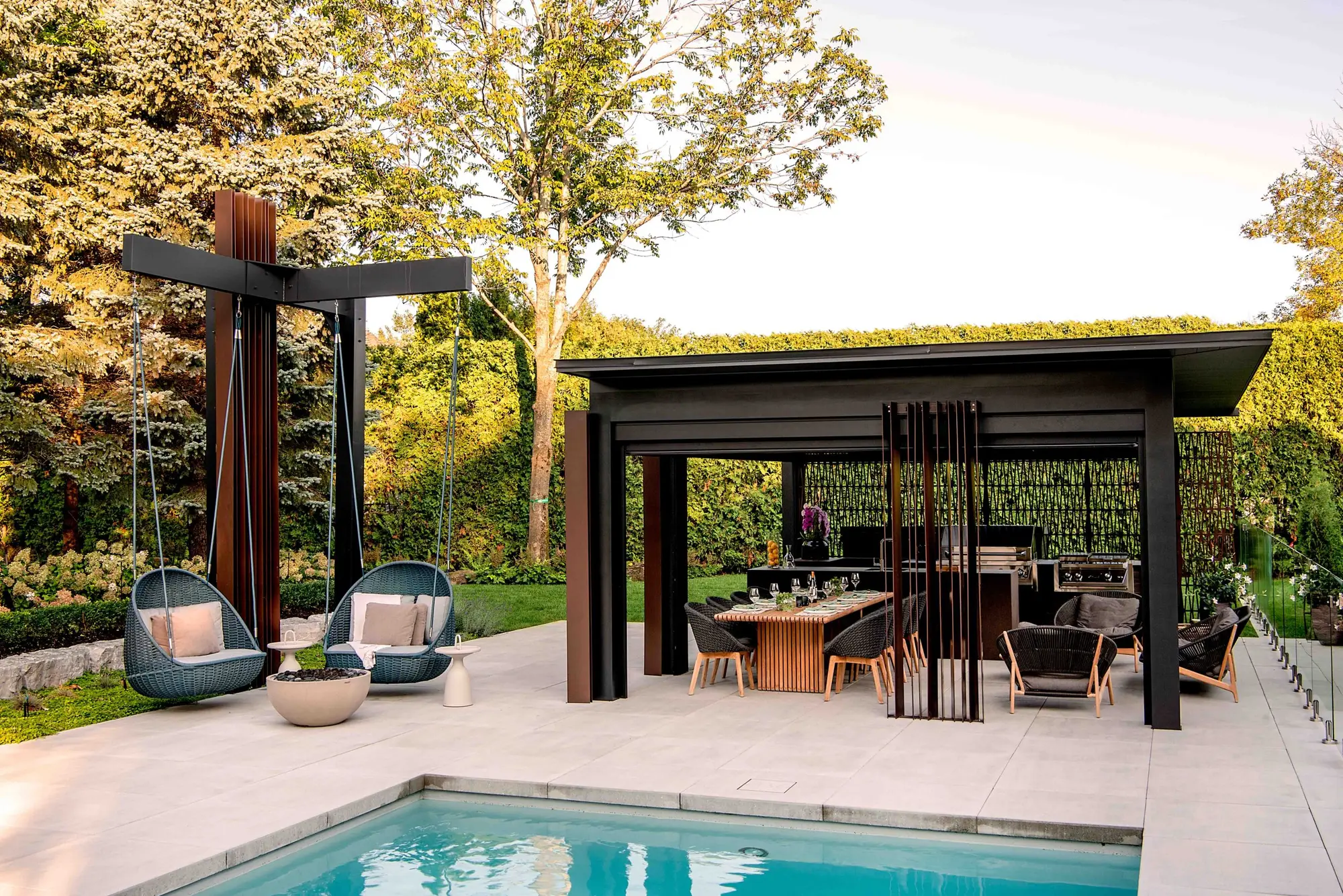 Piscine avec pavillon moderne et chaises suspendues